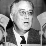 Photograph President Franklin Delano Roosevelt in front of microphones of U.S. radio networks.